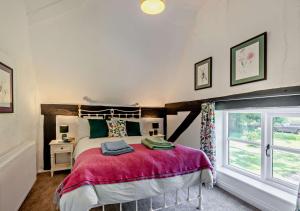 a bedroom with a large bed and a window at Walnut Cottage - Suffolk in Rumburgh
