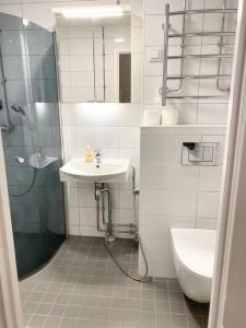 y baño con ducha, lavabo y aseo. en MELLUNMAKI Renovated 3 bedroom apt next to metro, en Helsinki