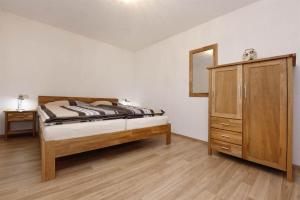 una camera da letto con un letto, un comò e uno specchio di Ferienwohnung Bitschnau Ulrike a Vandans