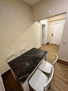 a room with a black counter top and white chairs at Ale Boutique Apartments in Antalya