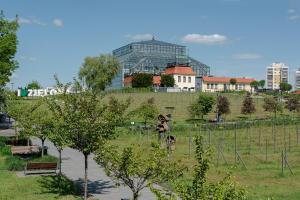 een park met een glazen gebouw op de achtergrond bij W12 Home Station in Zielona Góra