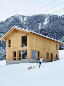 een persoon op ski's in de sneeuw voor een gebouw bij Haus Motta in Gaschurn