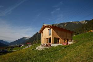 a house on the side of a hill with mountains at Haus Motta in Gaschurn