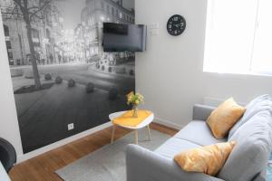 a living room with a couch and a tv on a wall at Le cocon in Angoulême