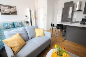 a living room with a blue couch and a kitchen at Le cocon in Angoulême +6 photos