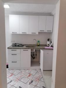 a white kitchen with a sink and white cabinets at Erme Apart Evler in Dernekpazarı