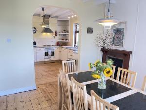 a kitchen and dining room with a table and chairs at Stratton Vow - a true 1920s Arts and Crafts house! in St Ives