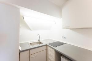 a white kitchen with a sink and a counter at Hotel Astoria am Urachplatz in Stuttgart