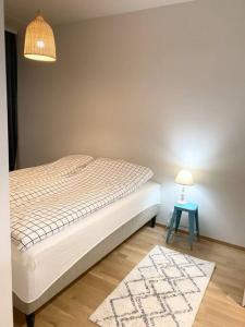 a bedroom with a bed and a table with a lamp at PEURANIITTY-2 Modern well equipped apartment in Espoo