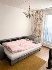 a bedroom with a bed with a pink comforter at PEURANIITTY-2 Modern well equipped apartment in Espoo