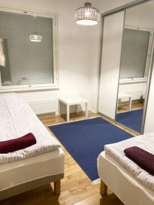 a room with two beds and a blue rug at VUOSAARI-2 Pure luxury for 100 m2 in Vuosaari in Helsinki