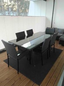 une table et des chaises en verre dans une pièce dans l'établissement VUOSAARI-2 Pure luxury for 100 m2 in Vuosaari, à Helsinki