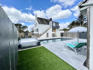 a backyard with a swimming pool and an umbrella at Propriété Ker Dagouët avec piscine in Carnac