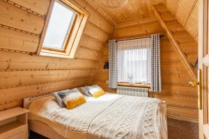 1 dormitorio con 1 cama en una cabaña de madera en Noclegi Siuster - komfortowe pokoje z widokiem na góry - doskonała lokalizacja, niedaleko Term Bukovina en Bukowina Tatrzańska