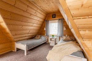 a bedroom with two beds in a log cabin at Noclegi Siuster - komfortowe pokoje z widokiem na góry - doskonała lokalizacja, niedaleko Term Bukovina in Bukowina Tatrzańska