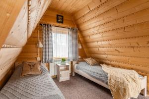 1 dormitorio con 2 camas en una cabaña de madera en Noclegi Siuster - komfortowe pokoje z widokiem na góry - doskonała lokalizacja, niedaleko Term Bukovina en Bukowina Tatrzańska