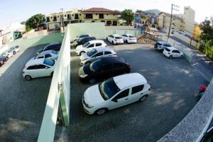 eine Gruppe von Autos, die auf einem Parkplatz geparkt sind in der Unterkunft HN-Hotel Natal Penha in Penha