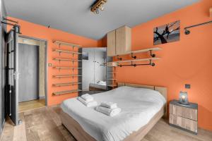 ein Schlafzimmer mit orangefarbenen Wänden und ein Bett mit Handtüchern in der Unterkunft L'Hippocrate - Charmant appartement avec terrasse in Toulouse