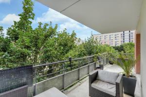 einen Balkon mit einem Stuhl und Blick auf ein Gebäude in der Unterkunft L'Hippocrate - Charmant appartement avec terrasse in Toulouse