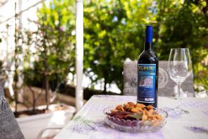 a bottle of wine and a bowl of food and a wine glass at Balic Apartments - ZF Hvar in Hvar