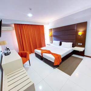 Habitación de hotel con cama y escritorio en Hotel Embaixador, en Beira