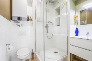 a white bathroom with a shower and a toilet at Appartement GRAND CONFORT BORD DE MER Rez-de-Chaussée RESIDENCE LA VAGUE in Houlgate