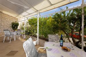 um pátio com uma mesa e uma garrafa de vinho em Apartments Balić em Hvar