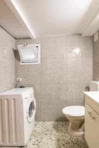 a bathroom with a washing machine and a toilet at ROMSUITES - Budget apartment at Center city, German colony Bahai gardens in Haifa