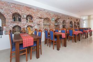 uma sala de jantar com mesas e cadeiras e uma parede de tijolos em Fifty one em Trogir