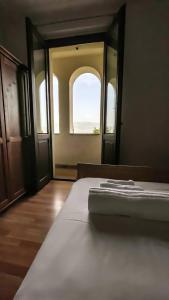 ein Schlafzimmer mit einem Bett und einem offenen Fenster in der Unterkunft AGRITURISMO LA CORTE DEI CAVALIERI in Montefalco