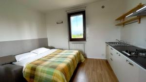 ein Schlafzimmer mit einem Bett, einem Waschbecken und einem Fenster in der Unterkunft AGRITURISMO LA CORTE DEI CAVALIERI in Montefalco