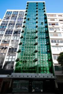 wysoki budynek z zielonymi szklanymi oknami w obiekcie Américas Benidorm Hotel w mieście Rio de Janeiro