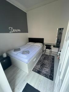 a small bedroom with a bed and a desk at Cozy modern space at the heart of the city in Debrecen