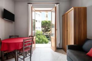 a dining room with a red table and a balcony at Residence Paradiso Bilocale 202 in Moneglia