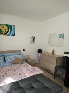 een slaapkamer met een bed, een bureau en een stoel bij La casa dei ricordi in Acqualagna