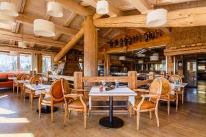 a restaurant with wooden ceilings and tables and chairs at Le Hameau de mon Père in Manigod