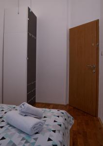 a bedroom with a bed and a wooden door at Lovran centar, apartman Gega in Lovran