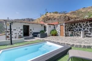 Villa con piscina frente a una casa en Casa Abuela Fela, en Vega de San Mateo