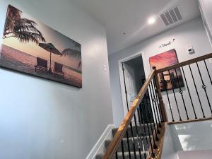 eine Treppe mit einem Gemälde an der Wand in der Unterkunft Bell Estates-Brand New Bay View, Beautiful Cottage in North Beach