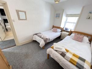 a bedroom with two beds and a window at Treholme, great space for a family beach holiday! in St Ives