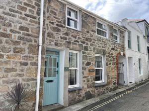 a stone house with a blue door on a street at Treholme, great space for a family beach holiday! in St Ives