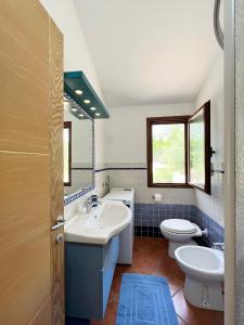 a bathroom with two sinks and a toilet at Casa Mare e Sole IUN R2610 in Cala Gonone
