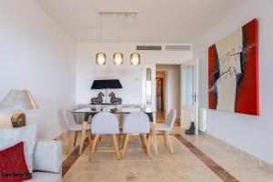 uma sala de jantar com uma mesa e cadeiras brancas em Royal Apartment w/shared pool, terrace &A/C em Málaga