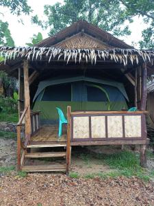 a green tent with a blue chair in front of it at Tony's Country Glamping with chalet with private wash room accommodation in El Nido
