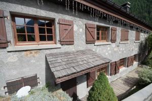 a house with brown windows and a wooden porch at Les Posettes, appartement Le Sizeray - Mont Blanc in Vallorcine