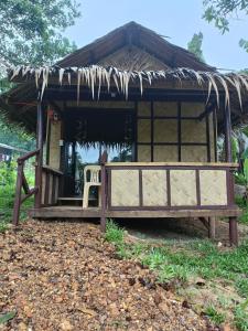 a small hut with a chair in front of it at Tony's Country Glamping with chalet with private wash room accommodation in El Nido