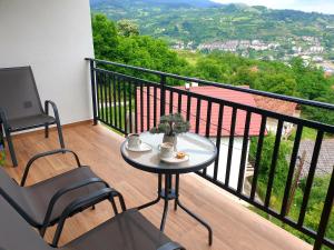 a table and chairs on a balcony with a view at Apartmani Višegradski pogled in Višegrad