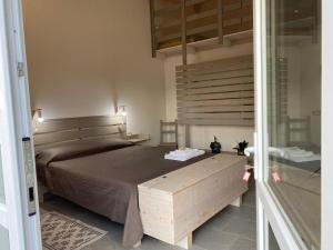 sypialnia z dużym łóżkiem z drewnianym zagłówkiem w obiekcie I tre schen w mieście Calasetta