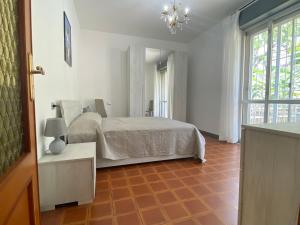 1 dormitorio con cama, mesa y ventana en Delizioso Bilocale ad Albenga con Terrazzo Vista Mare, en Albenga