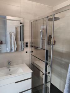 a bathroom with a sink and a glass shower at CHARMING APARTMENT IN CALDETES in Caldes d'Estrac